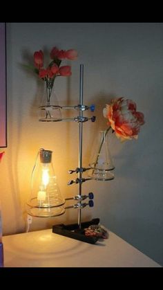 a lamp that is on top of a table next to a vase with flowers in it