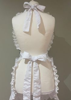 a white apron with ruffles and bows on it