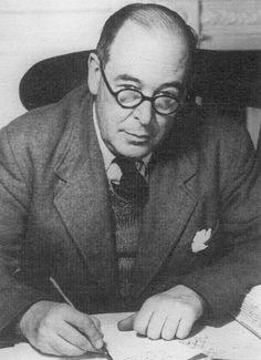 a man in a suit and tie sitting at a desk writing on a piece of paper