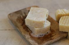 some pieces of cheese are on a wooden plate