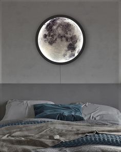 a bed with a large round mirror above it's headboard and the moon in the background