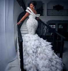 a woman in a white gown standing on stairs