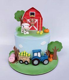 a birthday cake decorated with farm animals and tractor