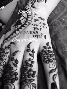 a woman's hand with henna tattoos on it and some words written in the middle