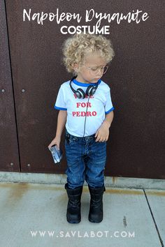 a little boy wearing headphones and standing in front of a sign