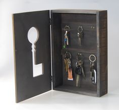 an open wooden box with keys and keychains in it