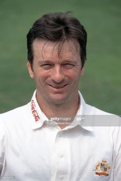 a man in white shirt smiling at the camera