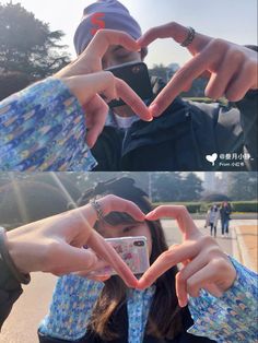 two people making the shape of a heart with their hands while taking a selfie