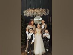 a group of people standing next to each other in front of a chandelier