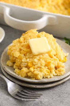 a plate topped with mashed potatoes and butter next to a casserole dish