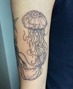 a woman's arm with a jellyfish tattoo on it