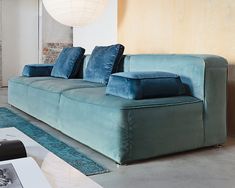 a blue couch with pillows on it in a living room