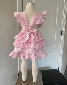 This darling all cotton pink gingham pinafore dress offers loads of ruffles in Carolina Gingham fabric from Robert Kaufman so it's premium cotton and breathable to feel great in the summertime. As is custom with Playful Princess items, the design has our signature flexible fit without fasteners and zippers that may break over time. Adjustable straps loop through the back to tie in a sweet bow. Throw it on over a shirt for a vintage pinafore look during any season. Gingham Dress With Ruffled Hem And Straps, Preppy Pink Dress For Spring, Preppy Pink Spring Dress, Cute Ruffled Strap Dresses For Picnic, Gingham Dress With Ruffled Straps And Details, Gingham Dress With Ruffled Straps And Ruffles, Sweet Gingham Dress With Ruffles, Pink Tiered Cotton Dress, Preppy Pink Summer Dress