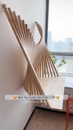 a wooden sculpture sitting on the side of a white wall next to a red chair