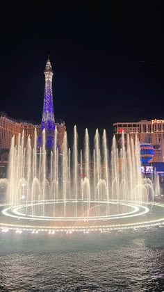 the fountains in front of the eiffel tower are lit up with blue lights