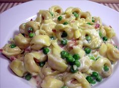 a white plate topped with pasta and peas