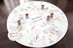 a white table topped with lots of crayons on top of a wooden floor