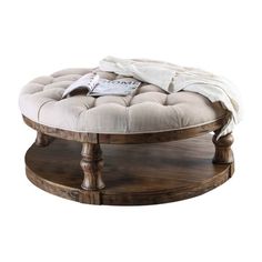 a round wooden table with a white blanket on top