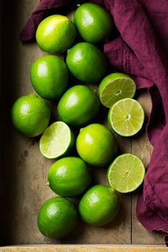 limes are arranged on a wooden cutting board