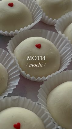 some white chocolates with red hearts on them are arranged in small paper cups that say mott'n mochi