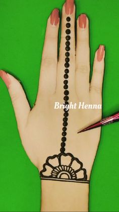 a henna tattoo is being drawn on the palm of a woman's hand