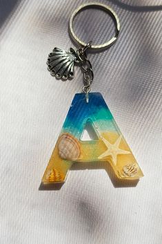 a keychain with a letter and seashells on it