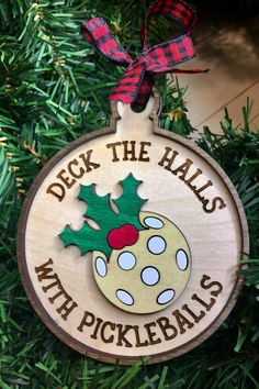 a wooden ornament hanging from a christmas tree that says deck the balls with pickleballs