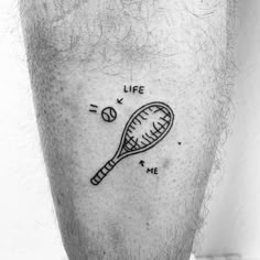 a black and white photo of a man's leg with a tennis racquet tattoo