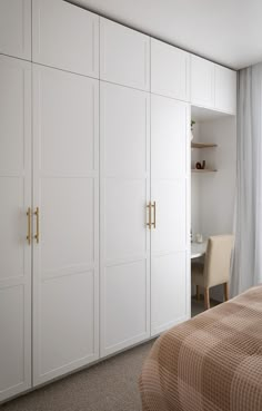 a bedroom with white closets and beige bedding