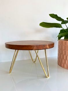 a wooden table sitting next to a potted plant on top of a white counter