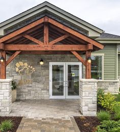 the front entrance to a building with stone pillars and wooden beams on it's sides