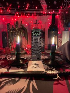 a table topped with candles and bottles filled with liquid next to a menu on a plate