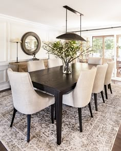 the dining room table is surrounded by beige chairs