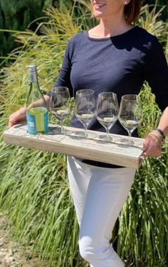 a woman holding a tray with wine glasses on it