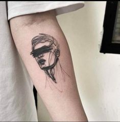 a man's arm with a black and white tattoo on it, which has a woman's face in the mirror