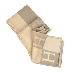 two beige and white scarfs with the letter f on them, both folded up