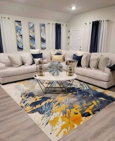 a living room with white couches and blue drapes on the windowsills