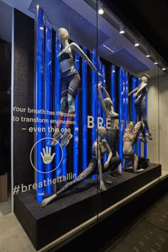 the display case is full of mannequins in blue and black colors with words written on them