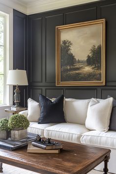 a living room filled with furniture and a painting hanging on the wall over a coffee table