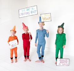 three children wearing funny costumes holding signs