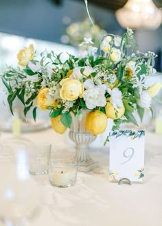 a vase filled with yellow and white flowers on top of a table