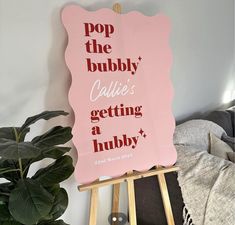 a pink sign that says pop the bubbly called getting a hubby