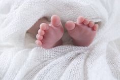 a baby's feet sticking out of a white blanket