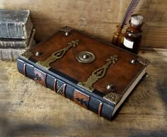 an old book is sitting on a table next to some books and a bottle with a pen in it