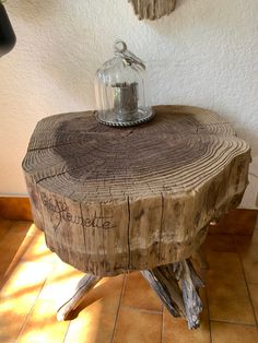 a wooden table with a glass jar on it's top and some branches around it