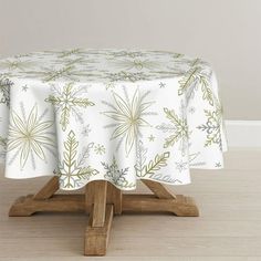 a table with a white and green floral design on it, sitting in front of a wall