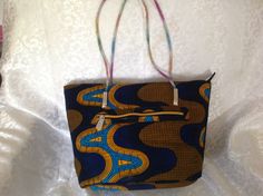 "Make a statement with this beautiful and stunning tote bag. This gorgeous tote was made with high quality African fabric print. This ankara bag would complete your outfit for every occasion, everyday casual wear. This Ankara tote made from African wax fabric with top zipper closure and inside pocket with zipper. It is fully lined It also has back pocket with zipper. Tote includes an inside pocket with zipper to keep items organized Dimensions: length 10\" by width 15\" by 4\" depth. The handle African Fabric Accessories, Ankara Bags, Accessories Fabric, Fabric Purse, Wax Fabric, Fabric Purses, Fabric Tote, Fabric Accessories, African Print Fabric