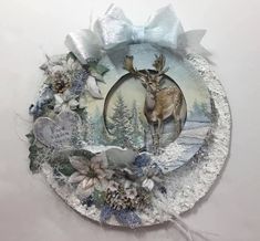 a plate with a deer on it and flowers around the edge, in front of a white wall