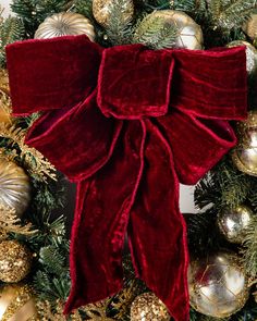 a christmas wreath with red velvet bow and gold ornaments