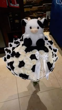 a teddy bear sitting on top of a cake covered in white and black frosting